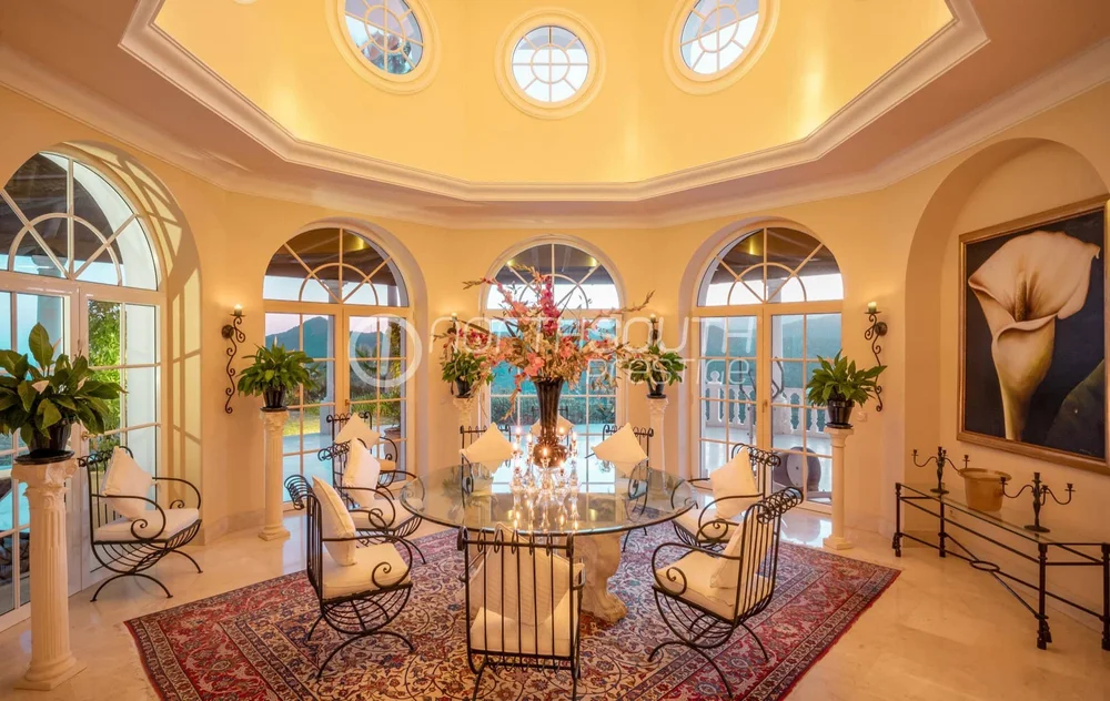 Dining room in villa in Marbella Spain featuring sea and mountain views and elegant wrought iron furnishings.