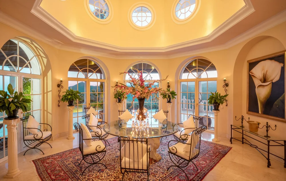 Salle à manger de la villa à Marbella, en Espagne, avec vue sur la mer et les montagnes et un élégant mobilier en fer forgé.