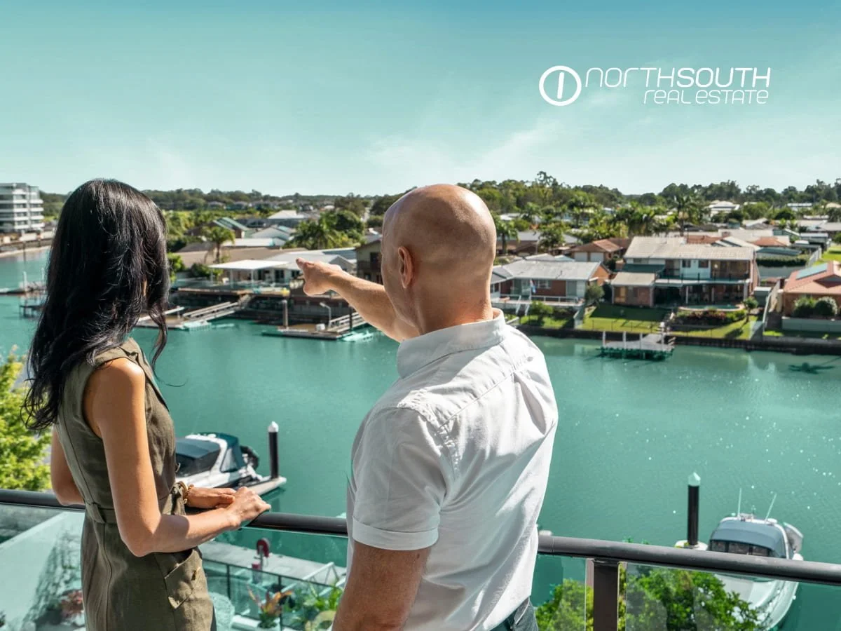A couple at the waterfront balcony of 3303 of Waterpoint Residences, Biggera Waters QLD.