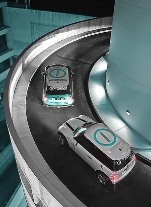 Two North South Real Estate branded Mini Coopers on a curved car park ramp