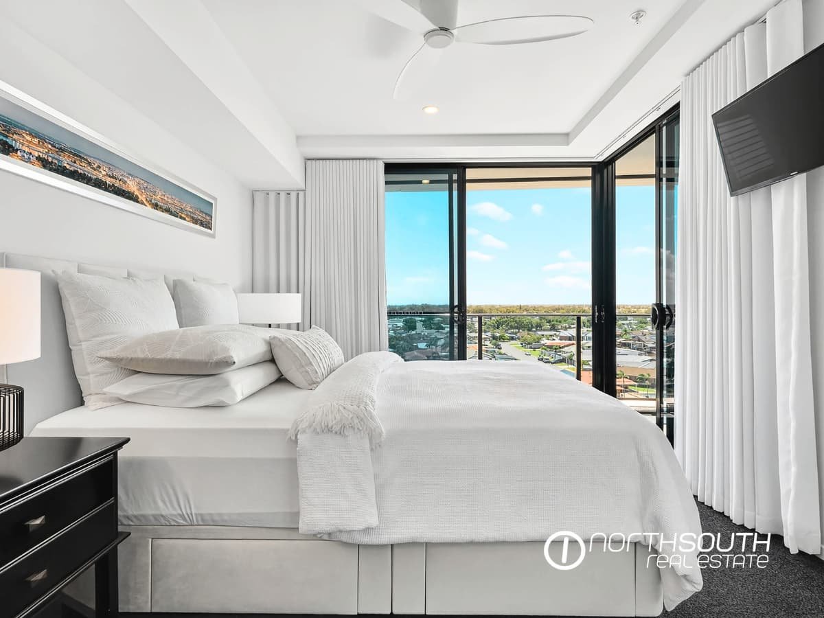 Main bedroom with balcony access and water views at 4705 Waterpoint Residences, Biggera Waters QLD.