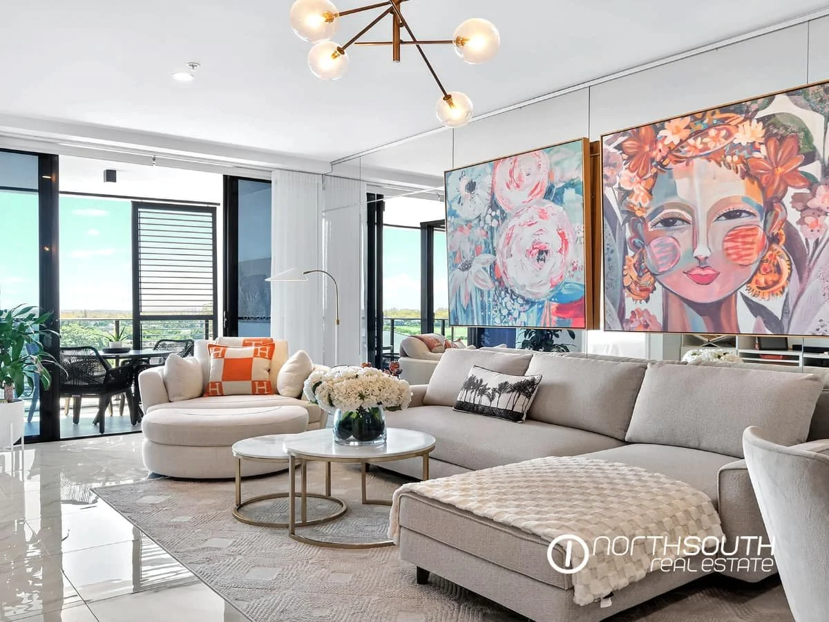 Open-plan living and dining area with mirrored wall and balcony views at 4705 Waterpoint Residences, Biggera Waters QLD.