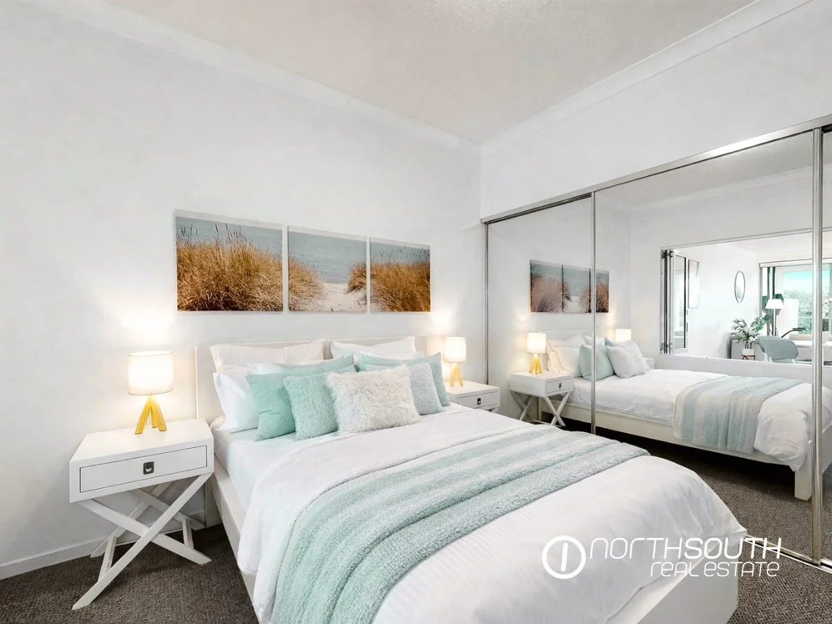 Bedroom in coastal tones with a mirrored built-in-robe at 2202 25 East Quay Drive Biggera Waters