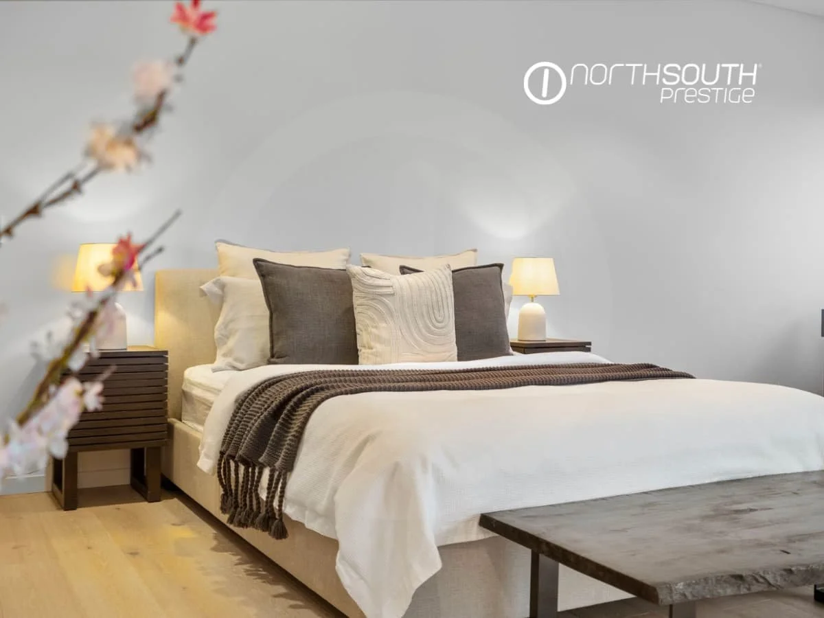 A king sized made bed in pastel tones with bedside tables and lamps in the master bedroom – Brisbane properties for sale Riparian Plaza apartment 4903 