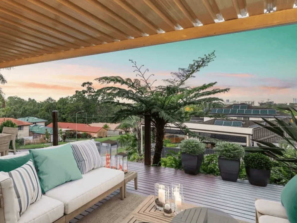 Elevated timber deck with outdoor lounge, potted plants and sunset views, from a property purchased through buyers advocacy. Parkwood,Gold Coast, Qld