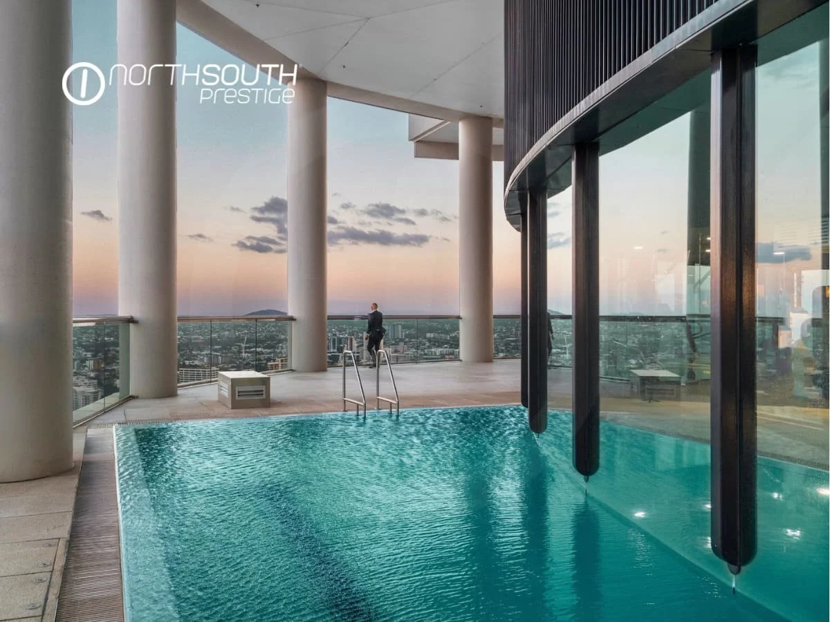A man looking at the sunset from recreational Facilities with an outdoor pool – Brisbane properties for sale Riparian Plaza apartment 4903 