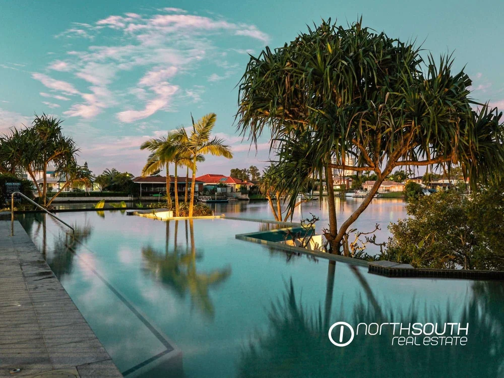 Reflections on the pool surface at dusk in properties for sale at Harbourside Biggera Waters