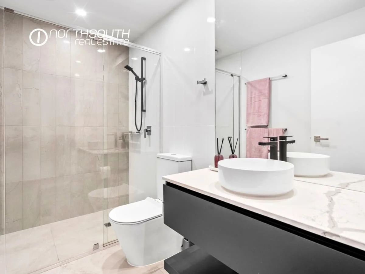 Second bathroom with glass shower and tiled floors at 51109 Waterpoint Residences, Biggera Waters QLD.