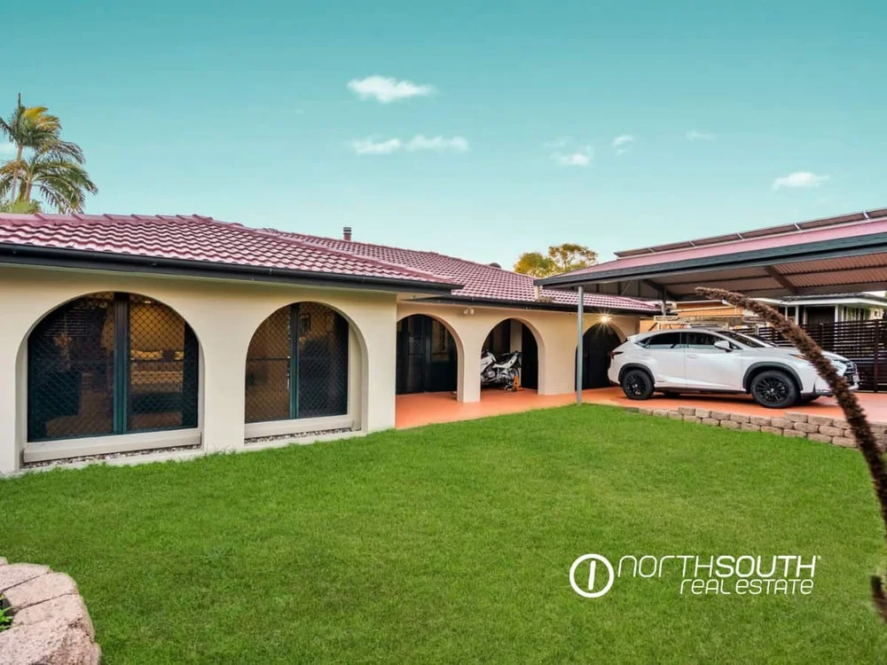 Front yard with manicured lawns and a car parked in the car port at 7 Bligh Street, Rochedale South QLD 4123
