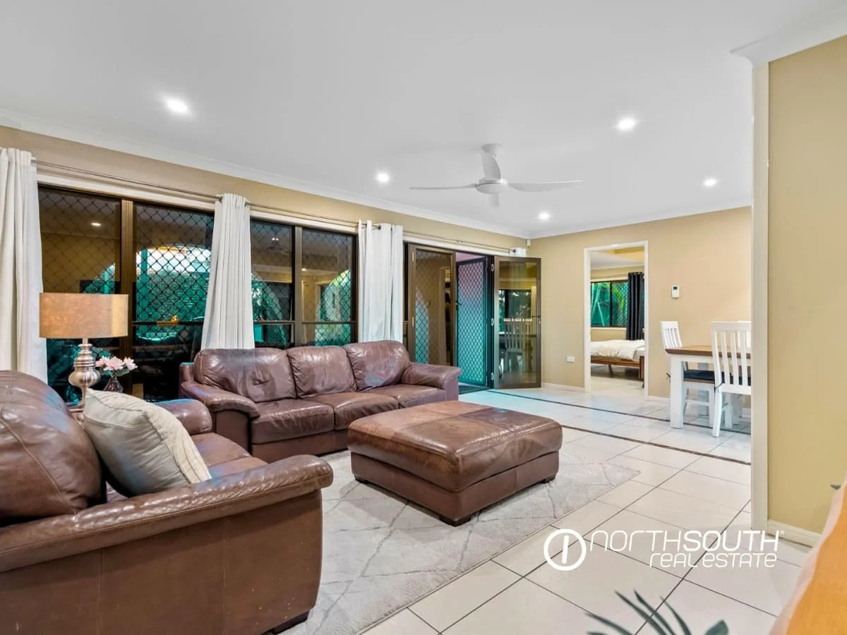 Living and dining area furnished with leather lounge, TV, fireplace and dining table and chairs at 7 Bligh Street, Rochedale South QLD 4123