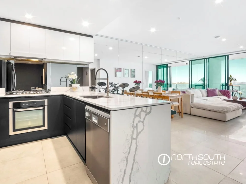 Spacious kitchen, living and dining zone with balcony access at 51109 Waterpoint Residences, Biggera Waters QLD.
