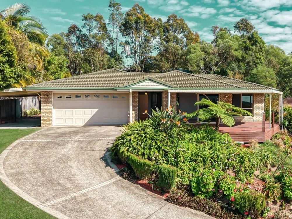 Front exterior of a single-level brick family home with landscaped garden and double garage, purchased through buyers advocacy in Parkwood Queensland. Parkwood, Gold Coast, Qld.