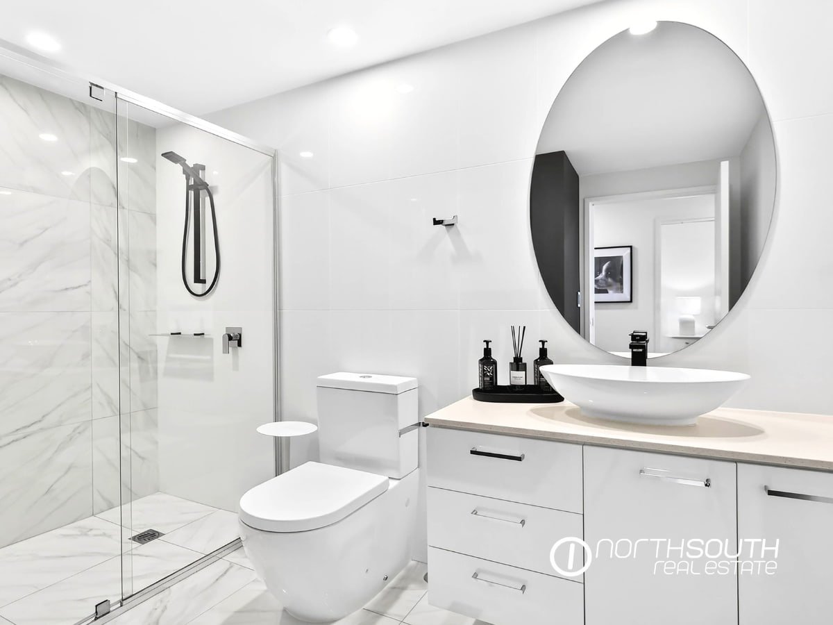 Second bathroom with glass shower and tiled floors at 4705 Waterpoint Residences, Biggera Waters QLD.