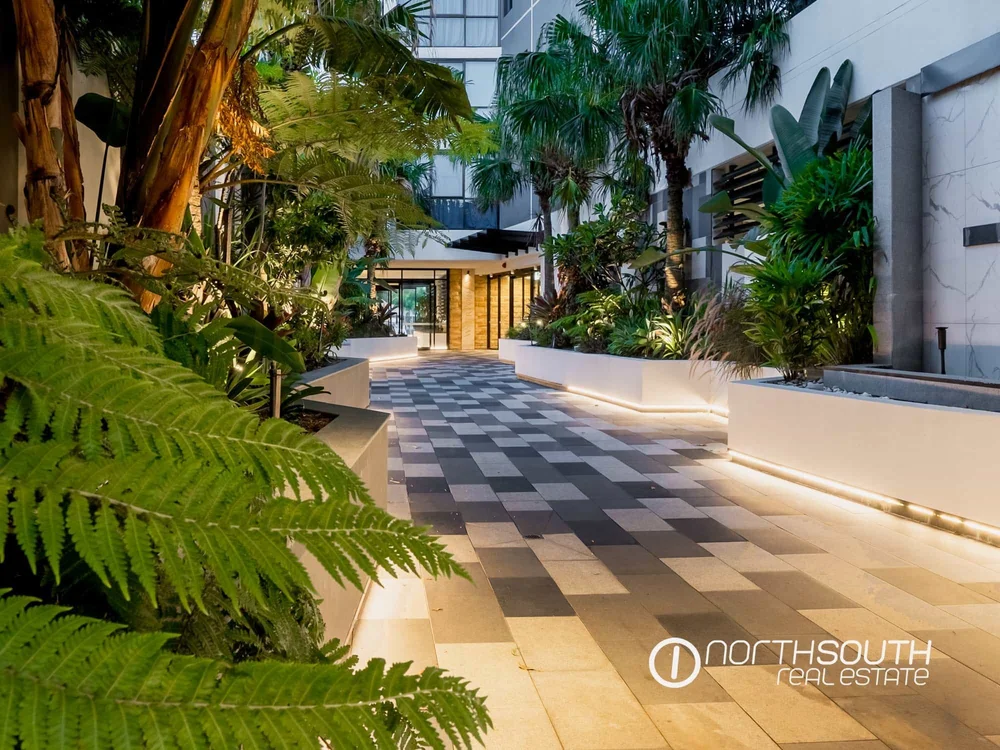 Entrance walkway surrounded by lush landscaping at WaterPoint Residences offering serene waterfront properties for sale in Biggera Waters