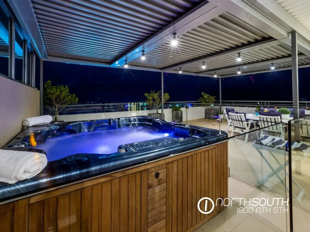 Image of properties for sale gold coast southport apartment penthouse spa bath at night with city lights.