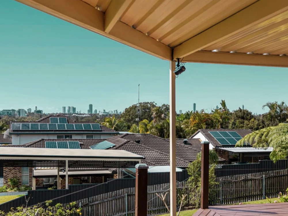 View from an elevated deck overlooking nearby rooftops, trees and distant city buildings, part of a home purchased through buyers advocacy. Parkwood, Gold Coast, Qld.