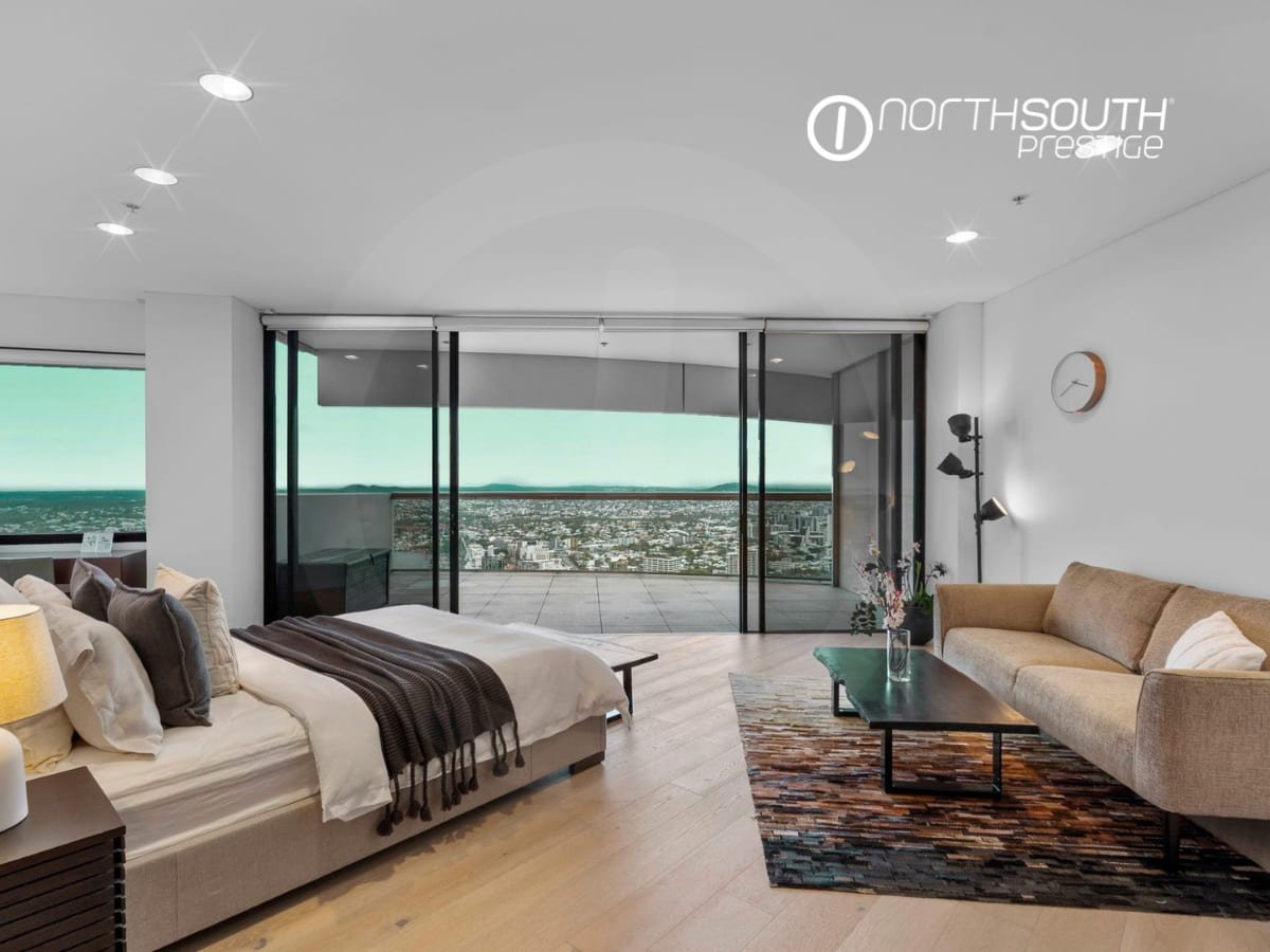 Expansive master bedroom with a king sized bed and a lounge flowing into balcony - Brisbane properties for sale Riparian Plaza apartment 4903 