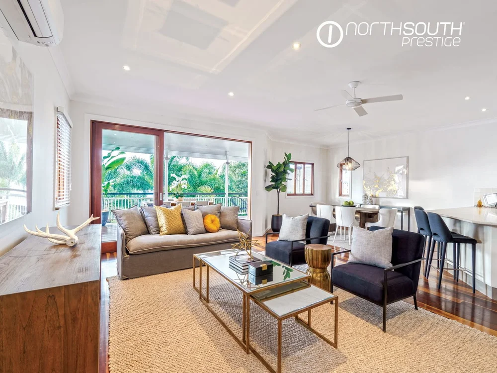 Modern house lounge with glass doors opening to verandah, representing well-managed investment property