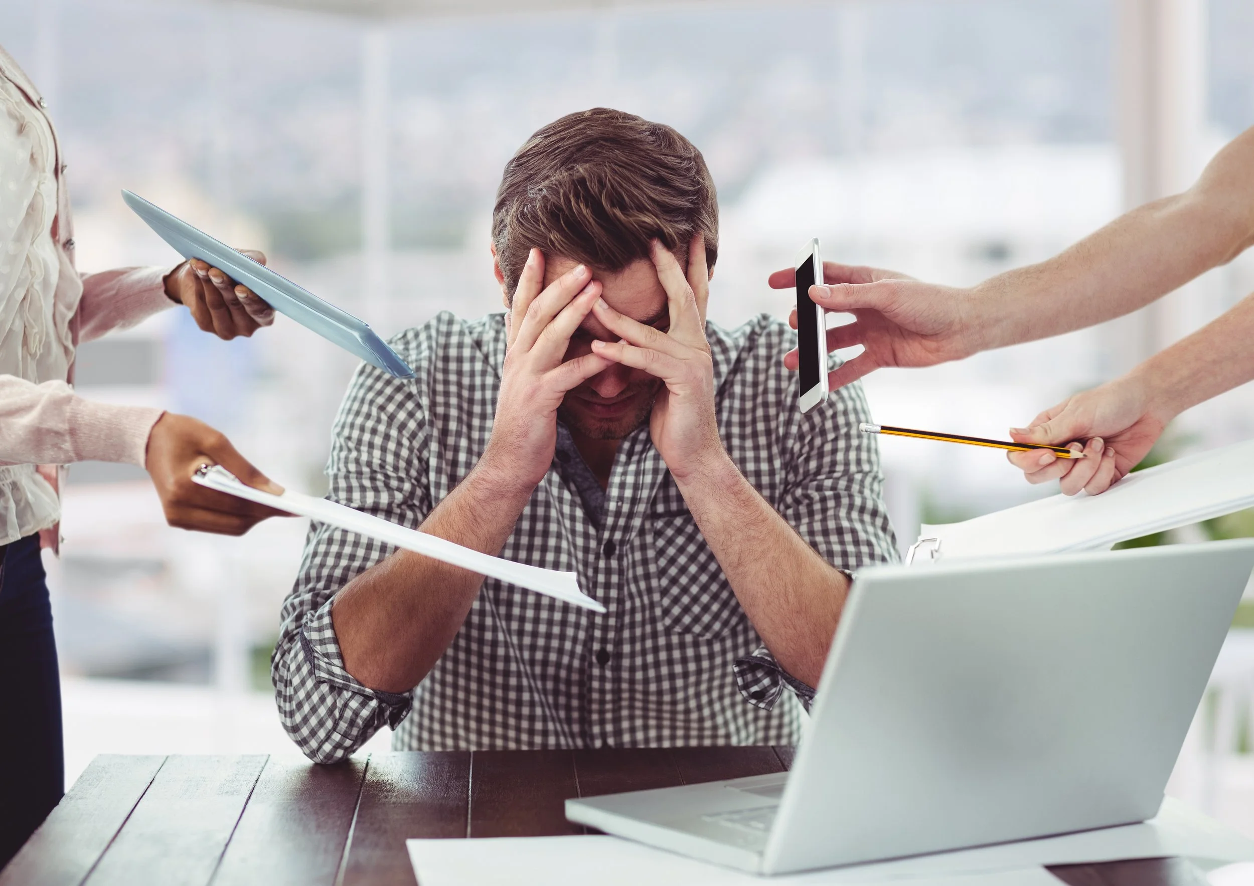 A young professional feeling overwhelmed with work,  surrounded by distractions and tasks demanding attention.
