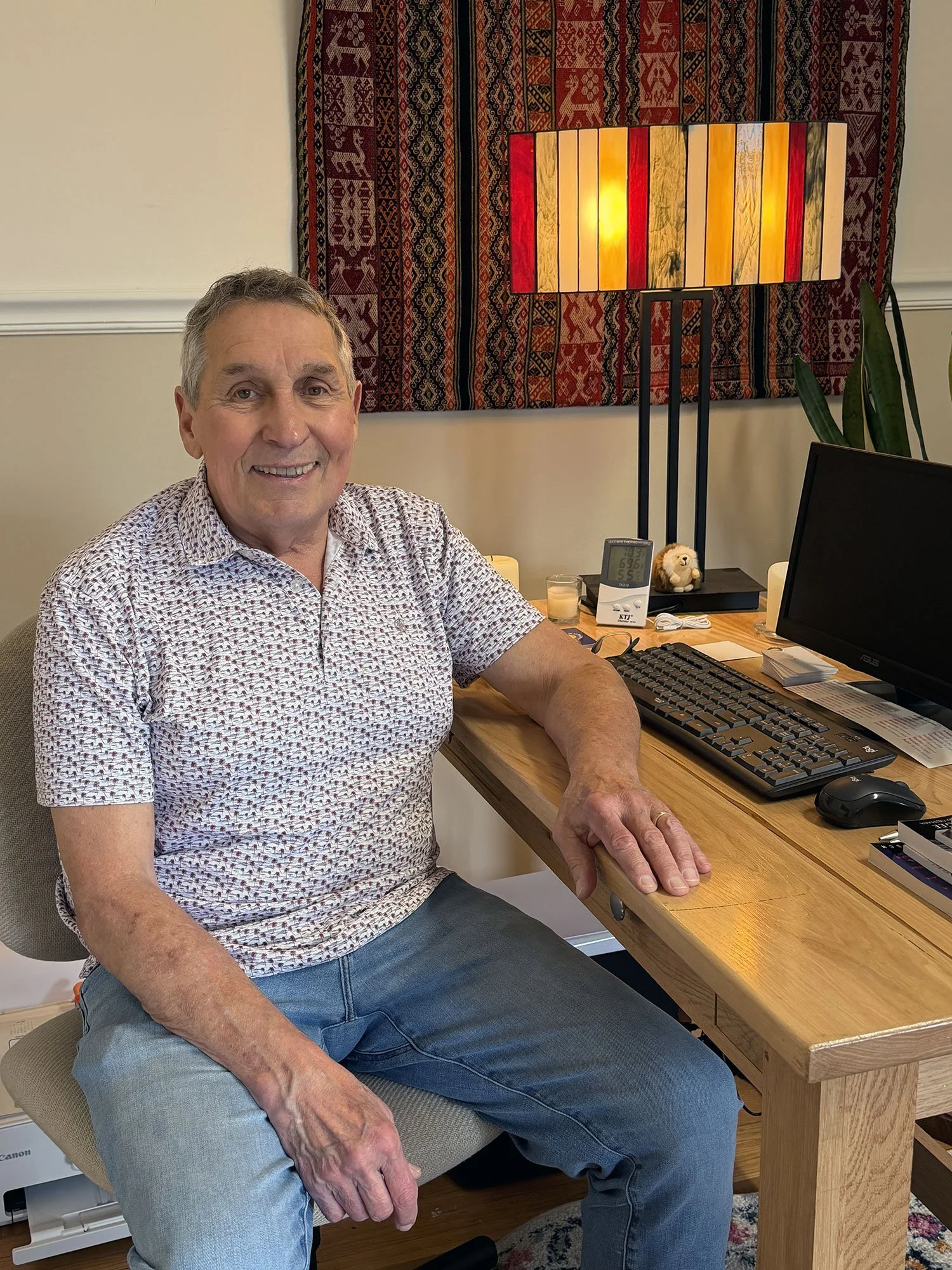 Roger Wheelock sitting at a desk smiling