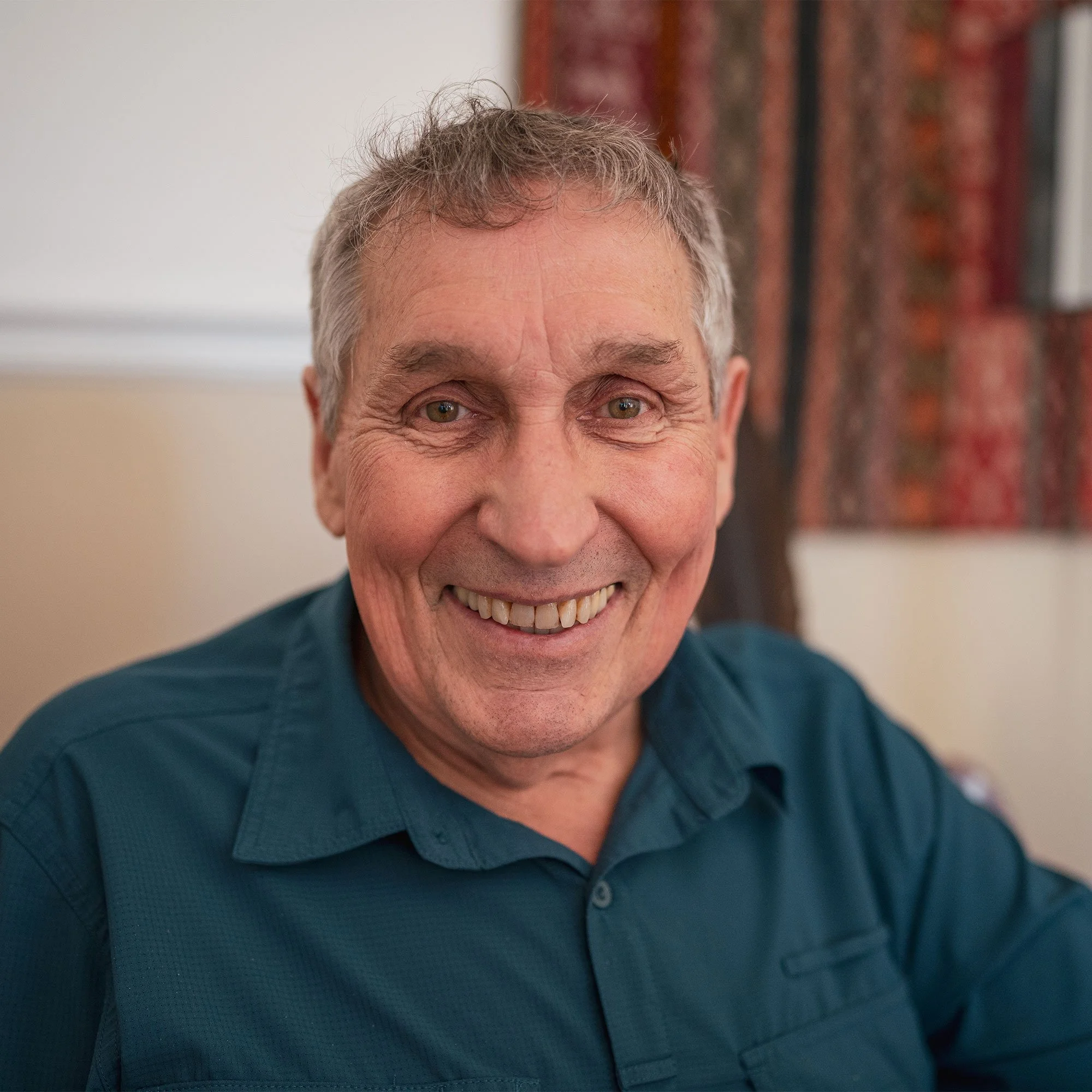 Roger Wheelock of Community Shaman smiling and wearing a navy blue shirt.