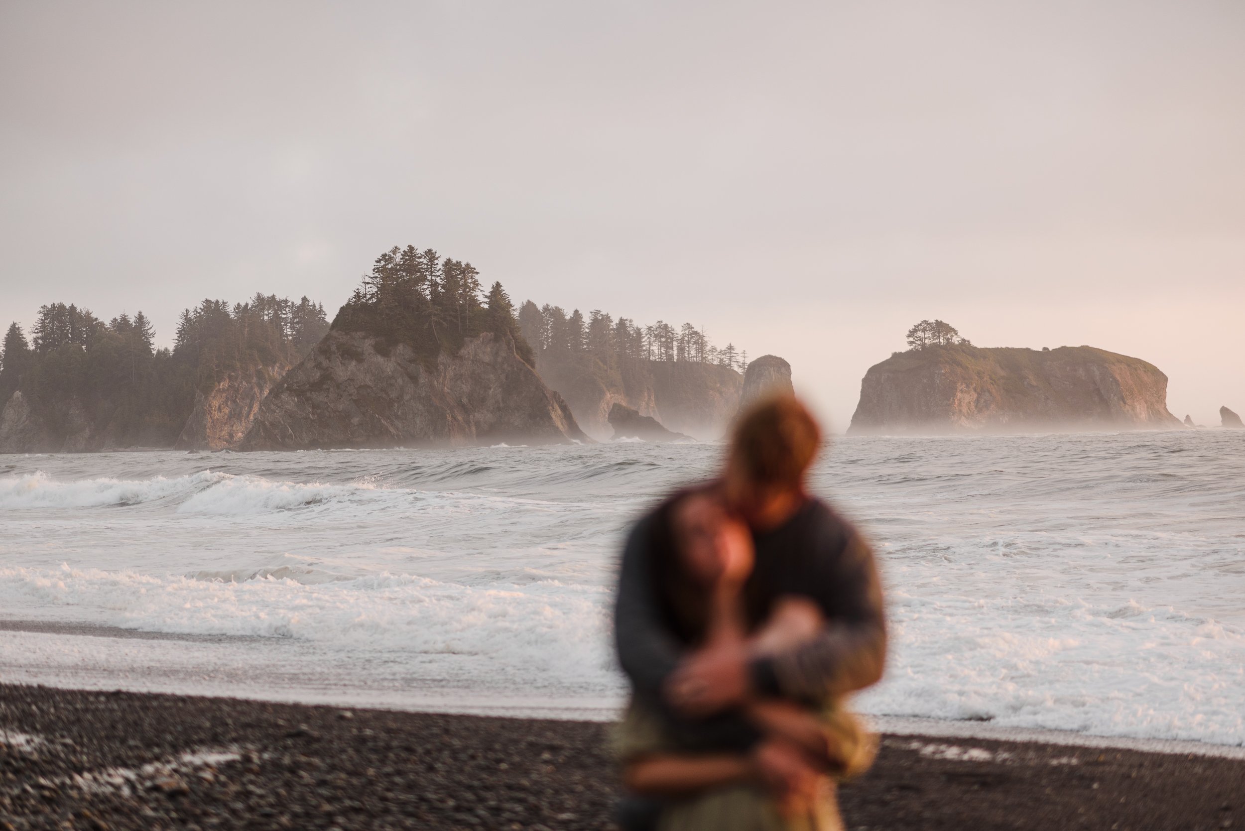 man and woman hugging on rialto beach washington