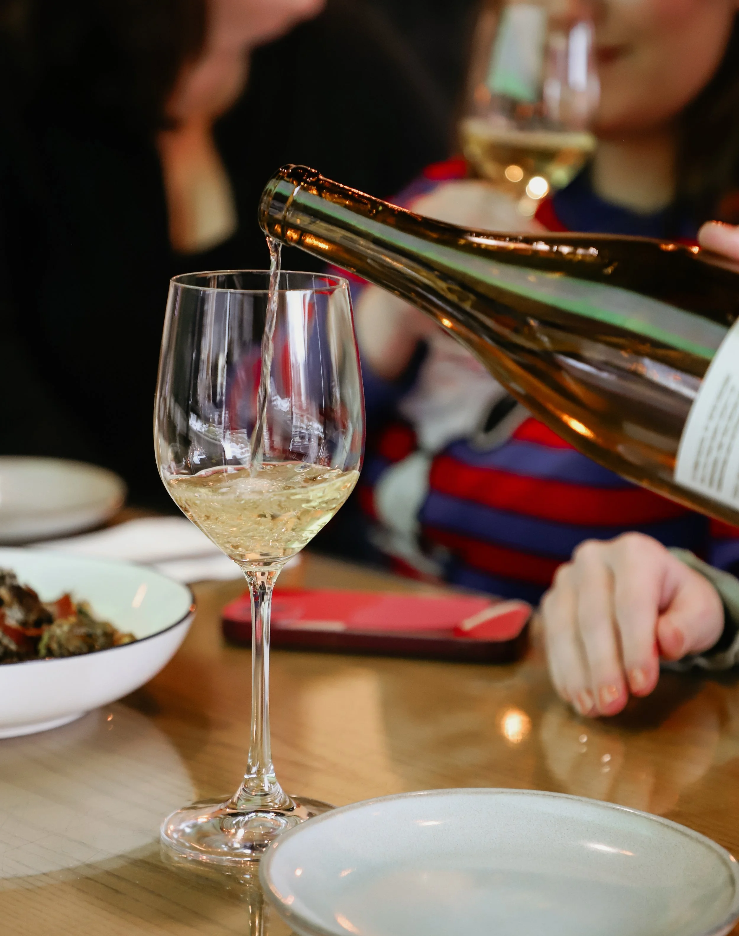 glass of white wine being poured on the dinner table at carnegie cellars rochester ny