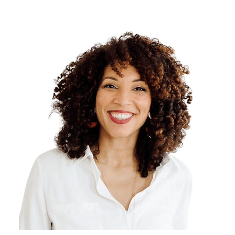 Smiling woman with curly brown hair wearing a white shirt against a white background.