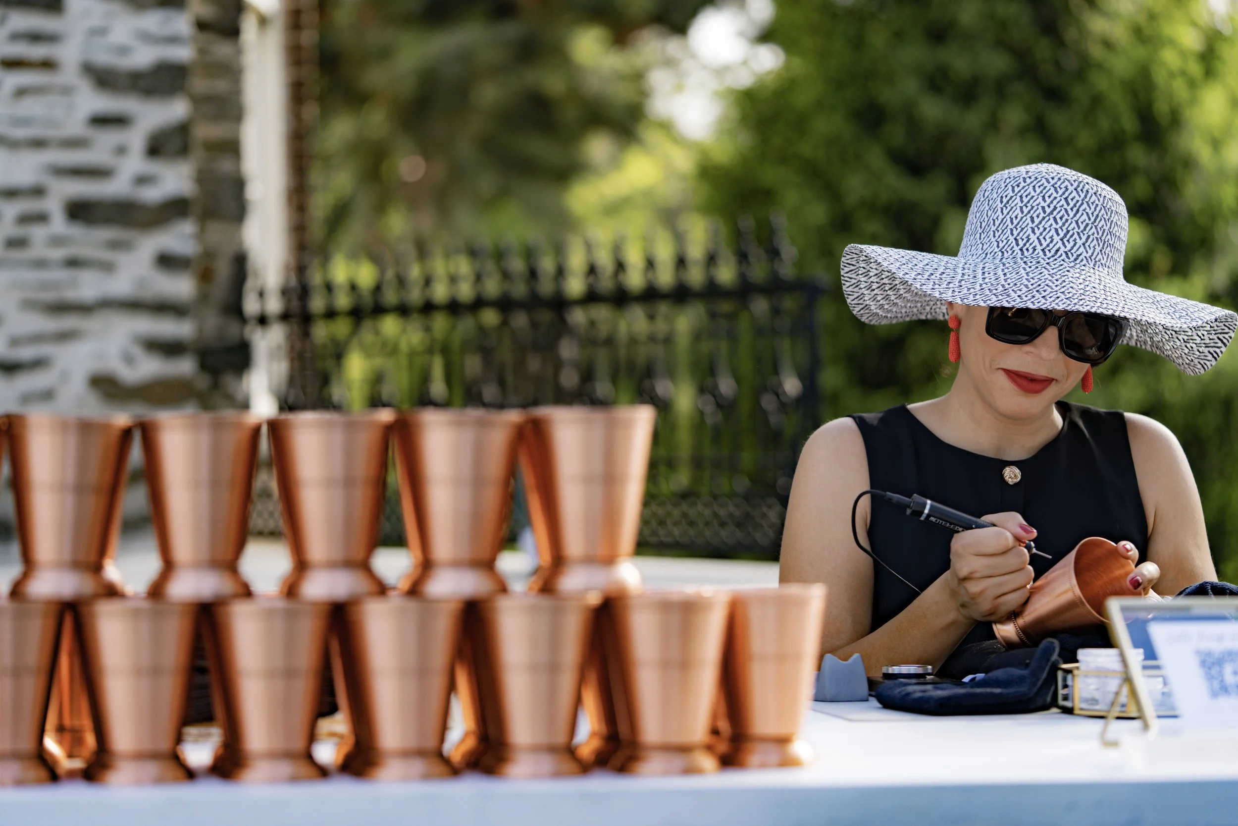 A woman is signing a tote bag at a popular store event with a crowd of women and children waiting in line behind her inside a retail store.