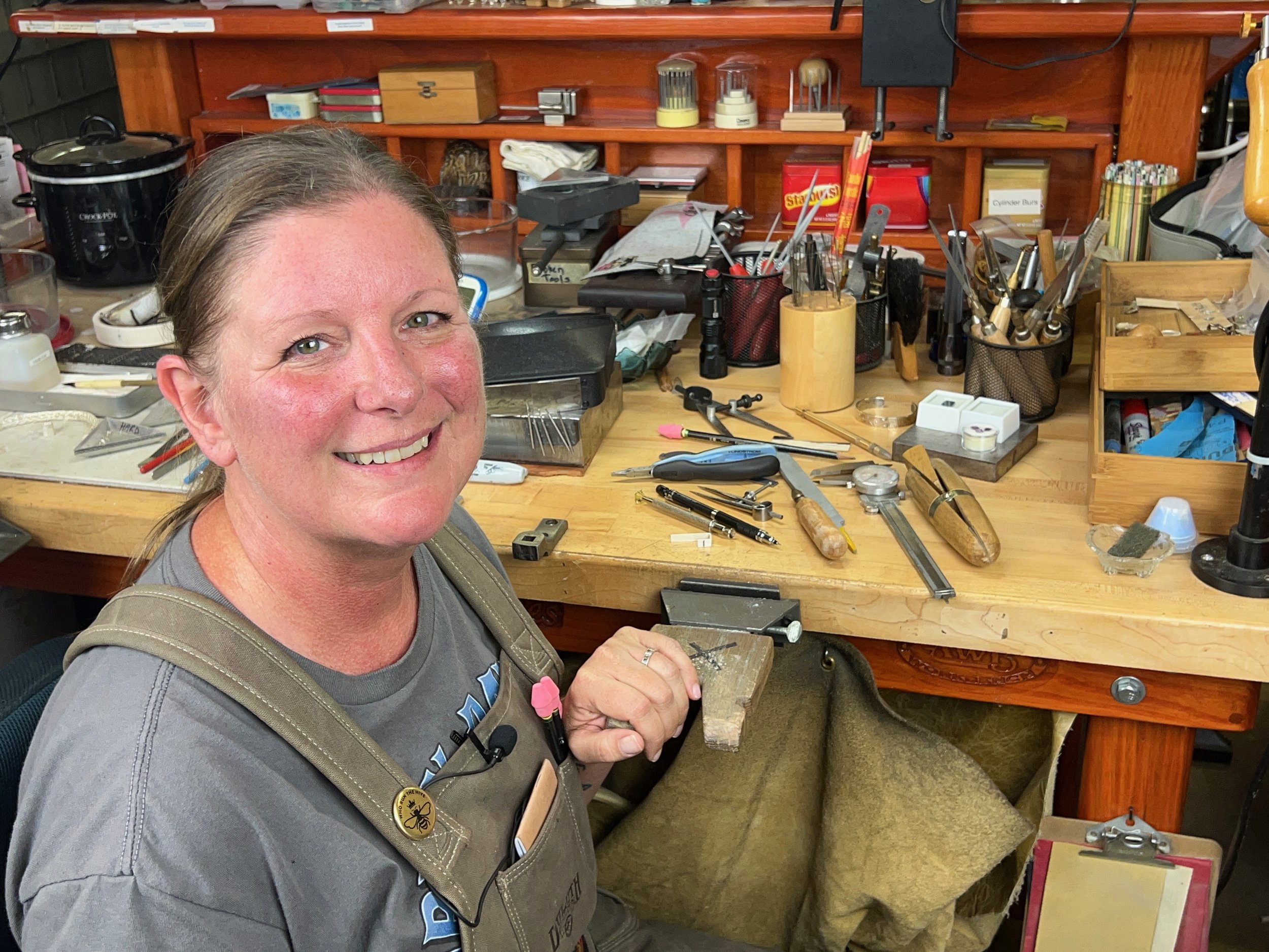 Julessa Scofield in front of jewelers workbench with lots of jewelry tools