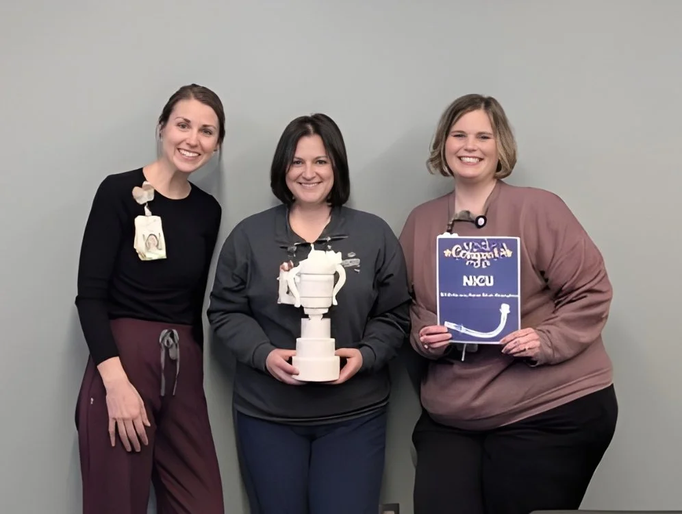 Three women holding trophy and certificate