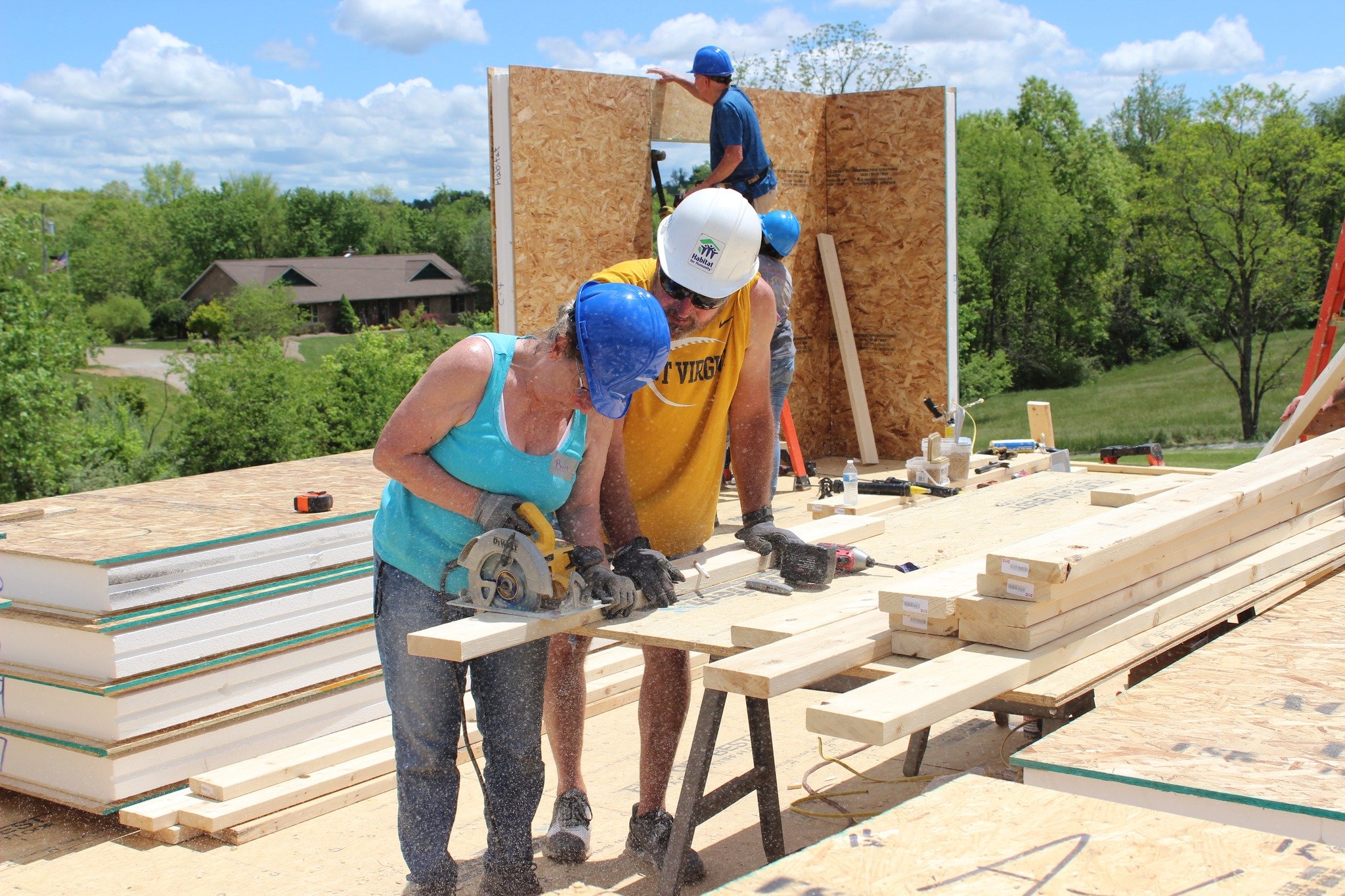 Women Build volunteers cutting 2x4's on the job site