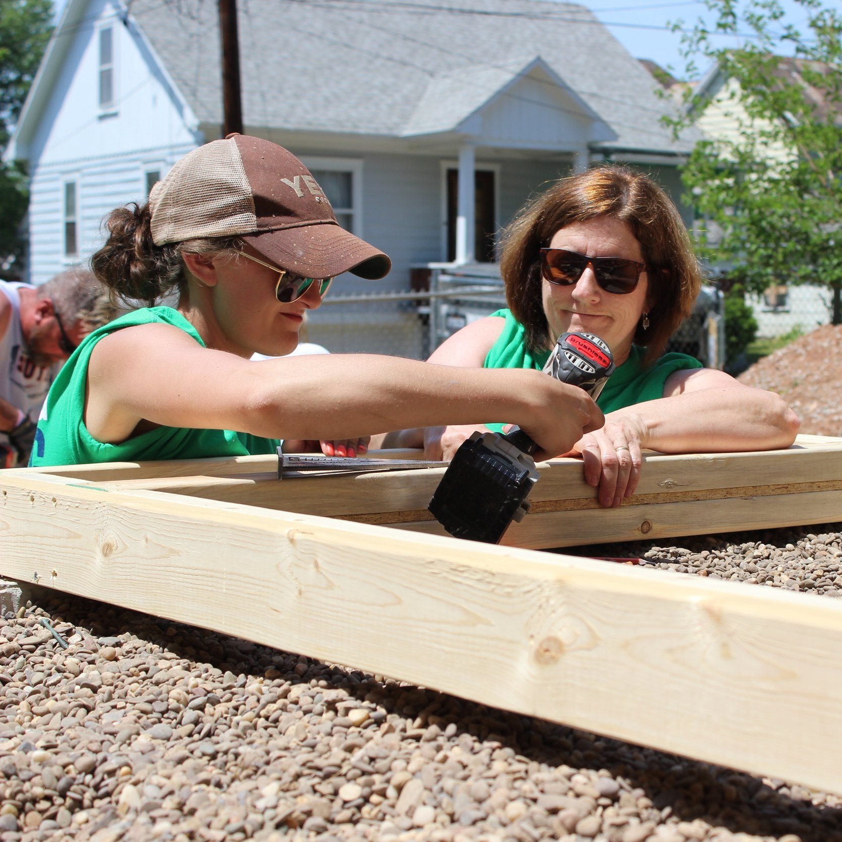 Two female volunteers building door frames