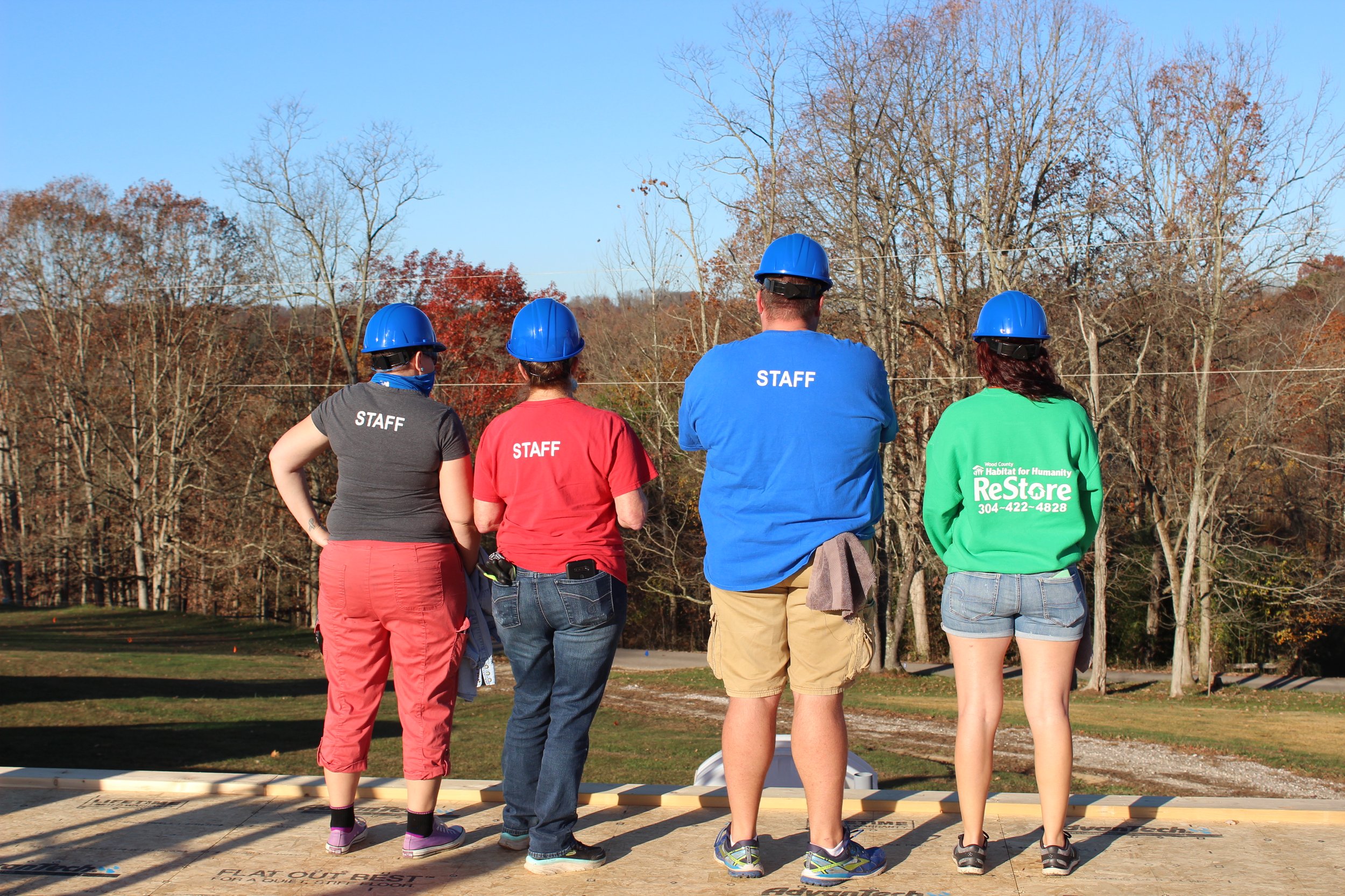 ReStore volunteers showing off their staff shirts on the job site