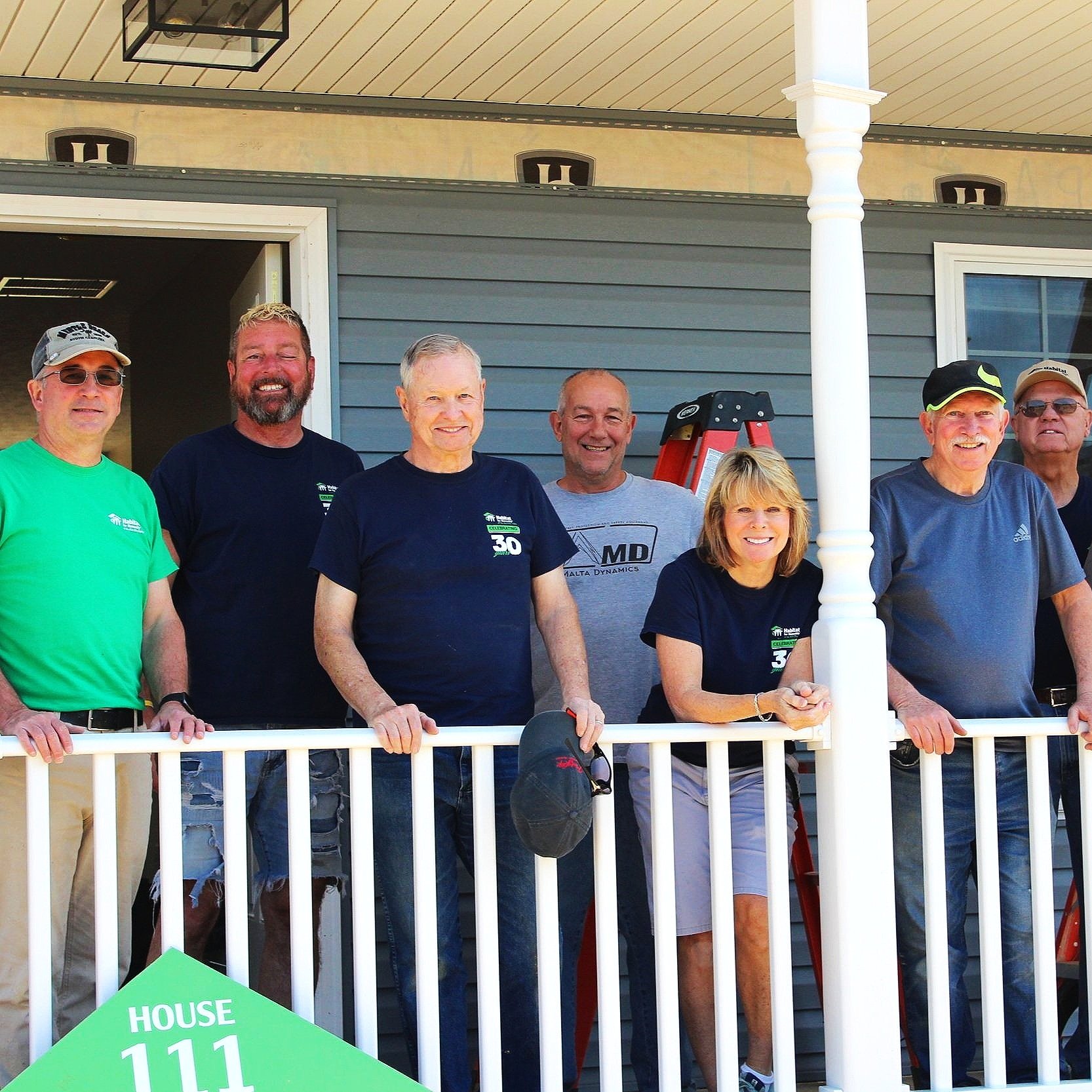 Group photo of volunteers on a porch