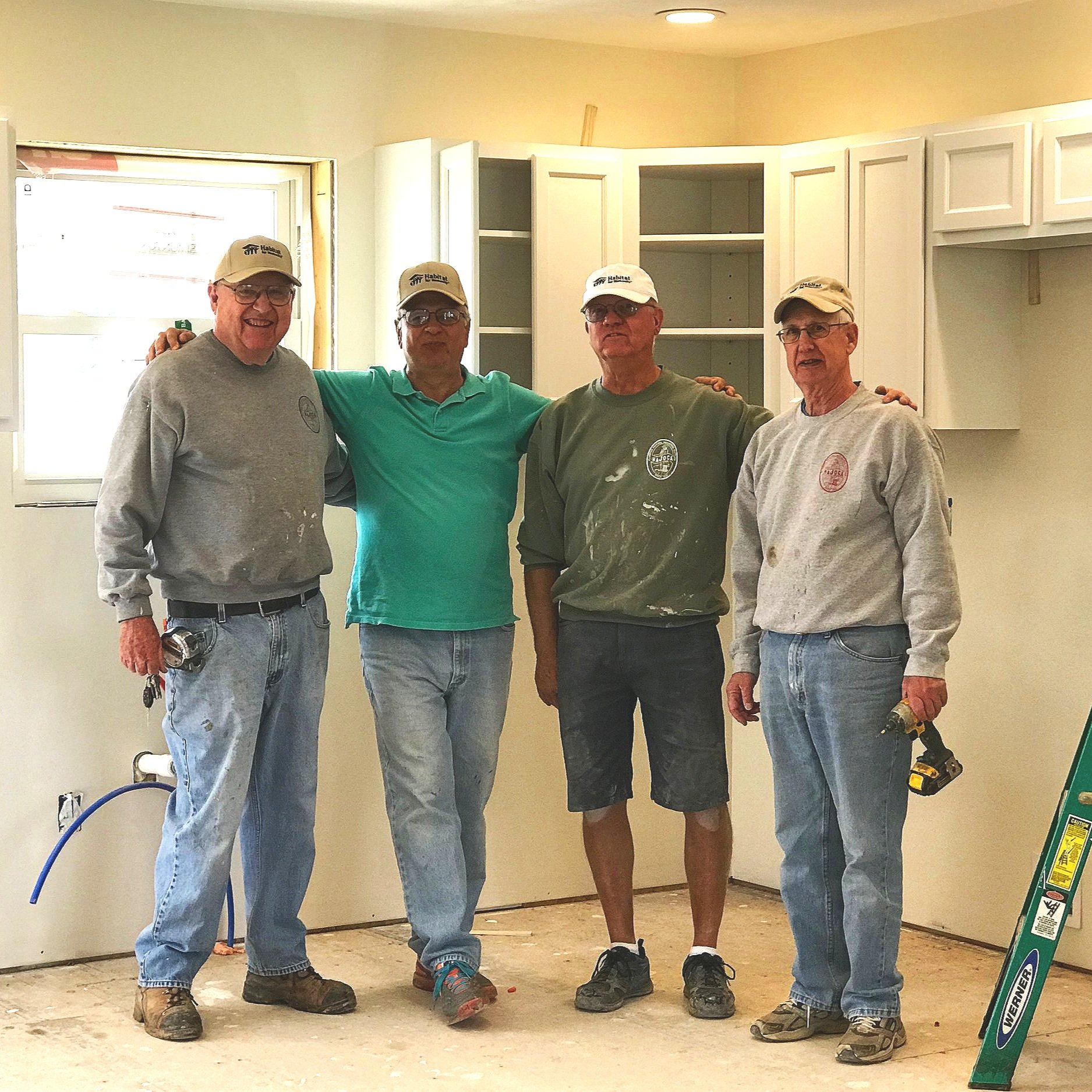 Four of the regular construction men posing in the kitchen, where they just finished cabinet install.