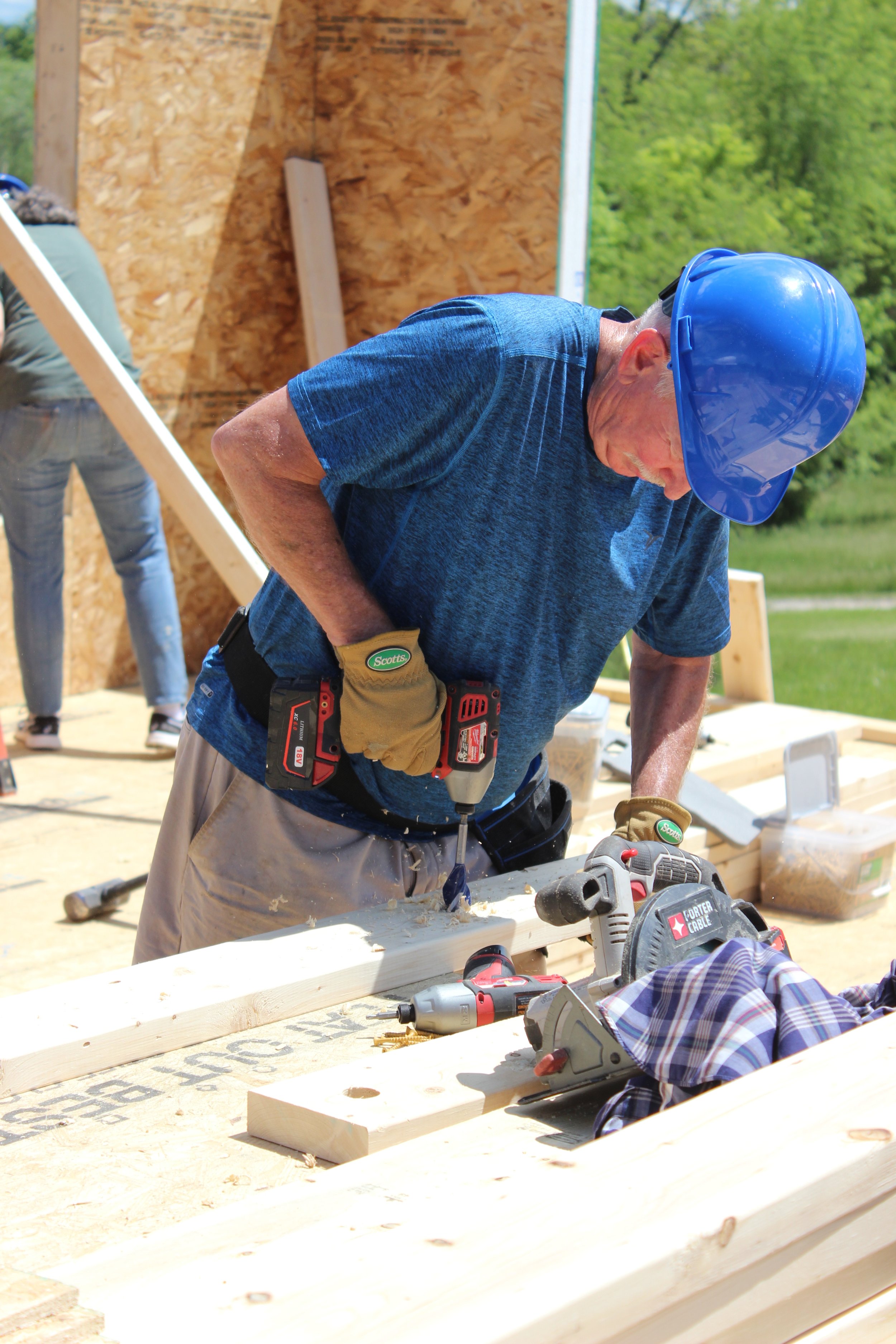 A volunteer cutting wood to size on the construction site