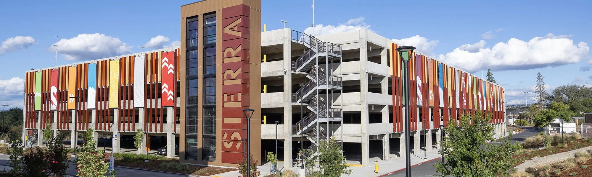 Multi-story parking garage with colorful vertical banners on the exterior and a prominent residential building with the word "STORAGE" on the side.