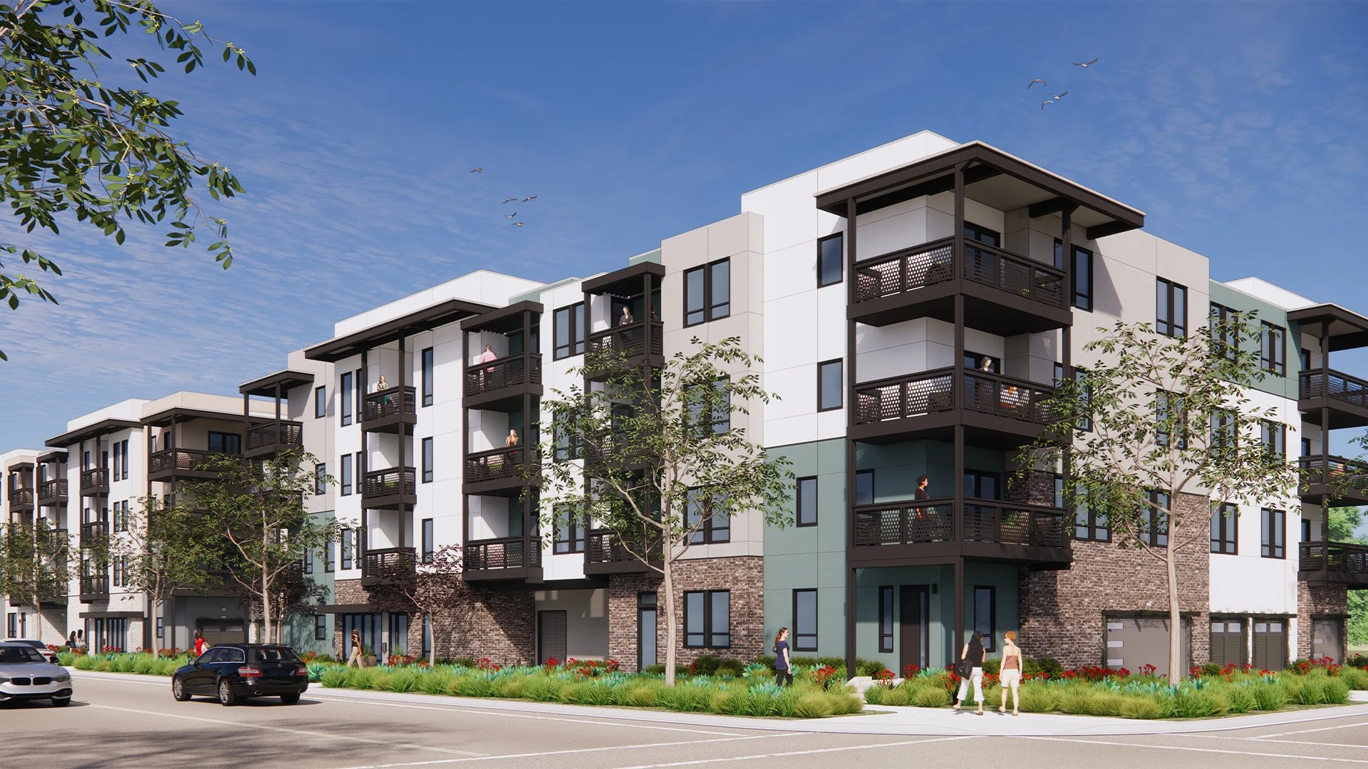 Modern multi-story apartment building with balconies, trees, and people walking on the sidewalk under a clear blue sky with birds flying.