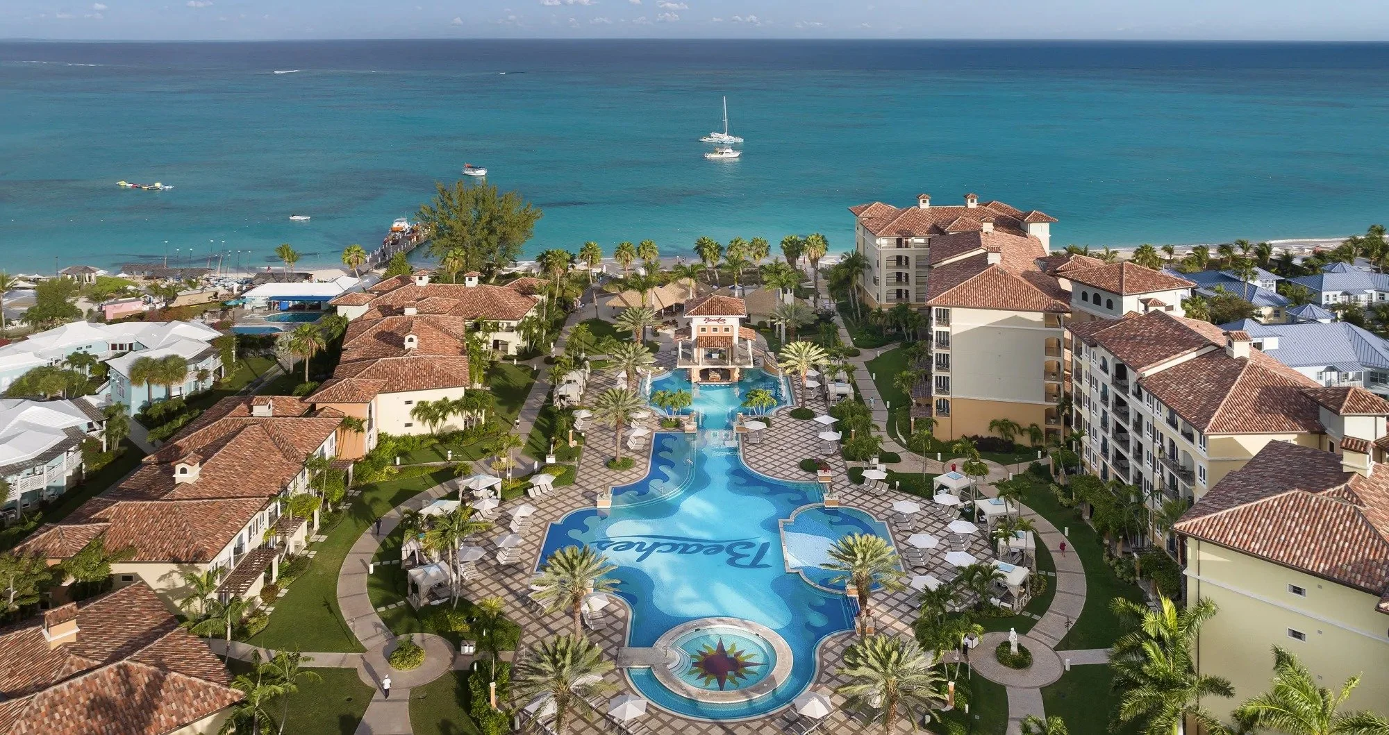 Italian Village at Beaches Turks and Caico.  You see the ocean, a large pool with swim-up bar, giant hot tub, luscious palm trees, and ample seating with umbrellas