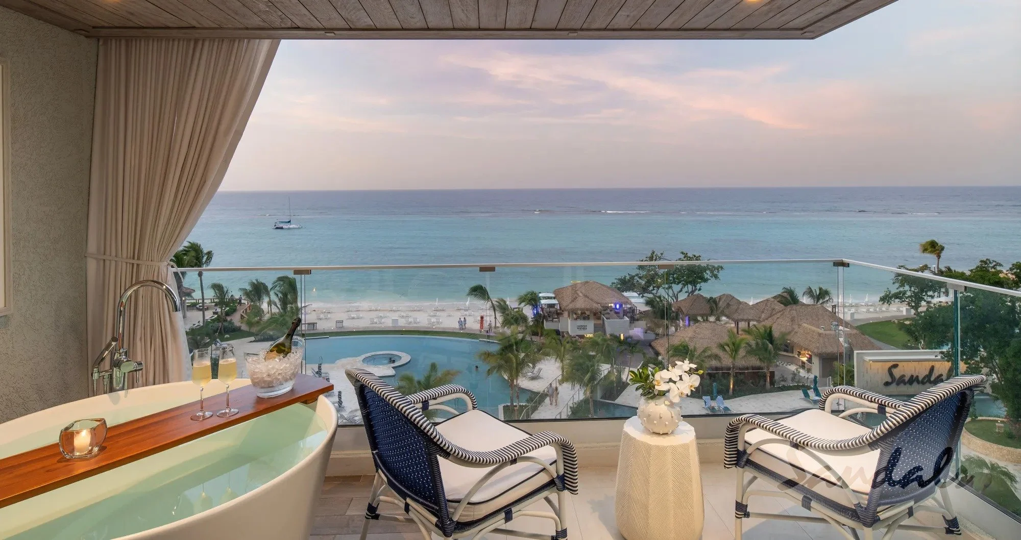 Spacious Balcony with Soaking Tub overlooking the pool and ocean.  Views complete with breezy palm trees and bungalows.  Picture of romance. 