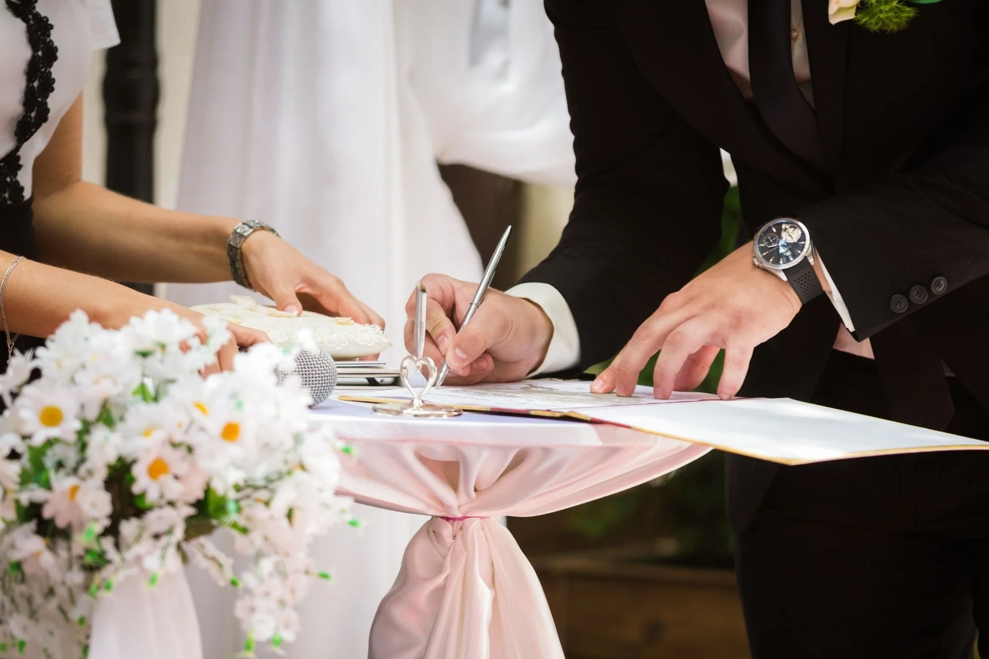 Couple signing the marriage license at the ceremony table.