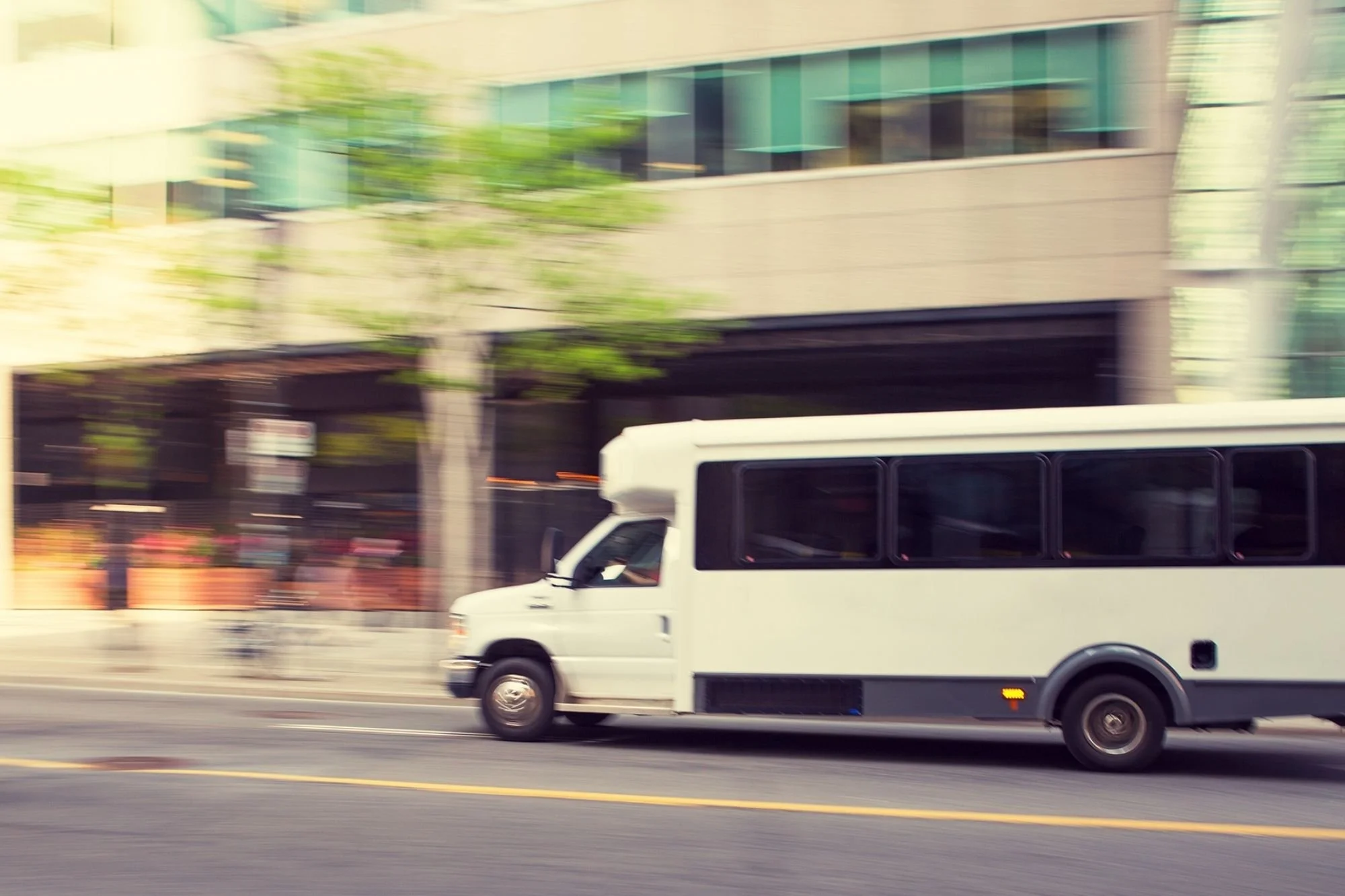 Small shuttle bus on city street—efficient hotel block transportation between ceremony and reception
