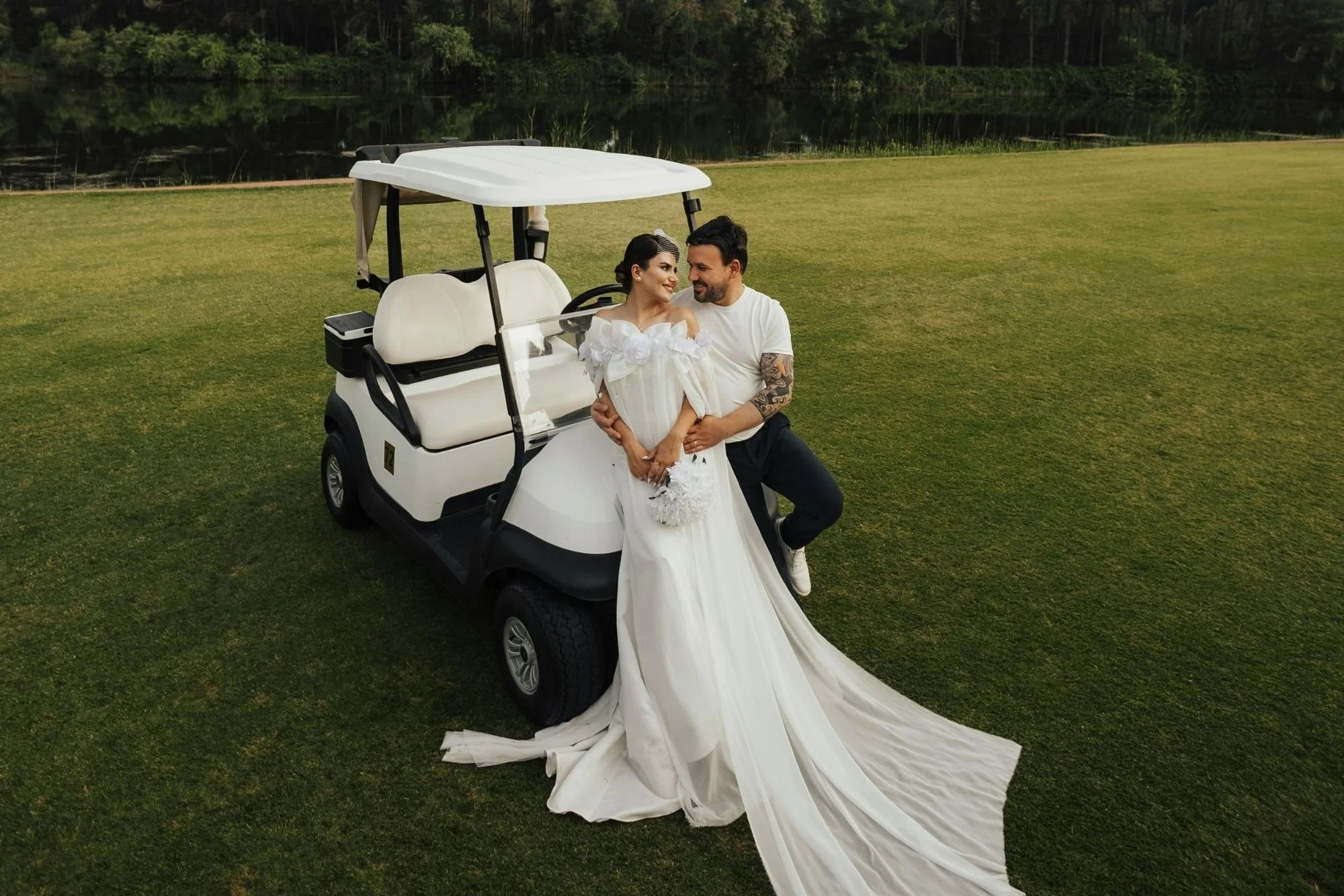 Couple posing with golf cart at venue—short-distance wedding transport
