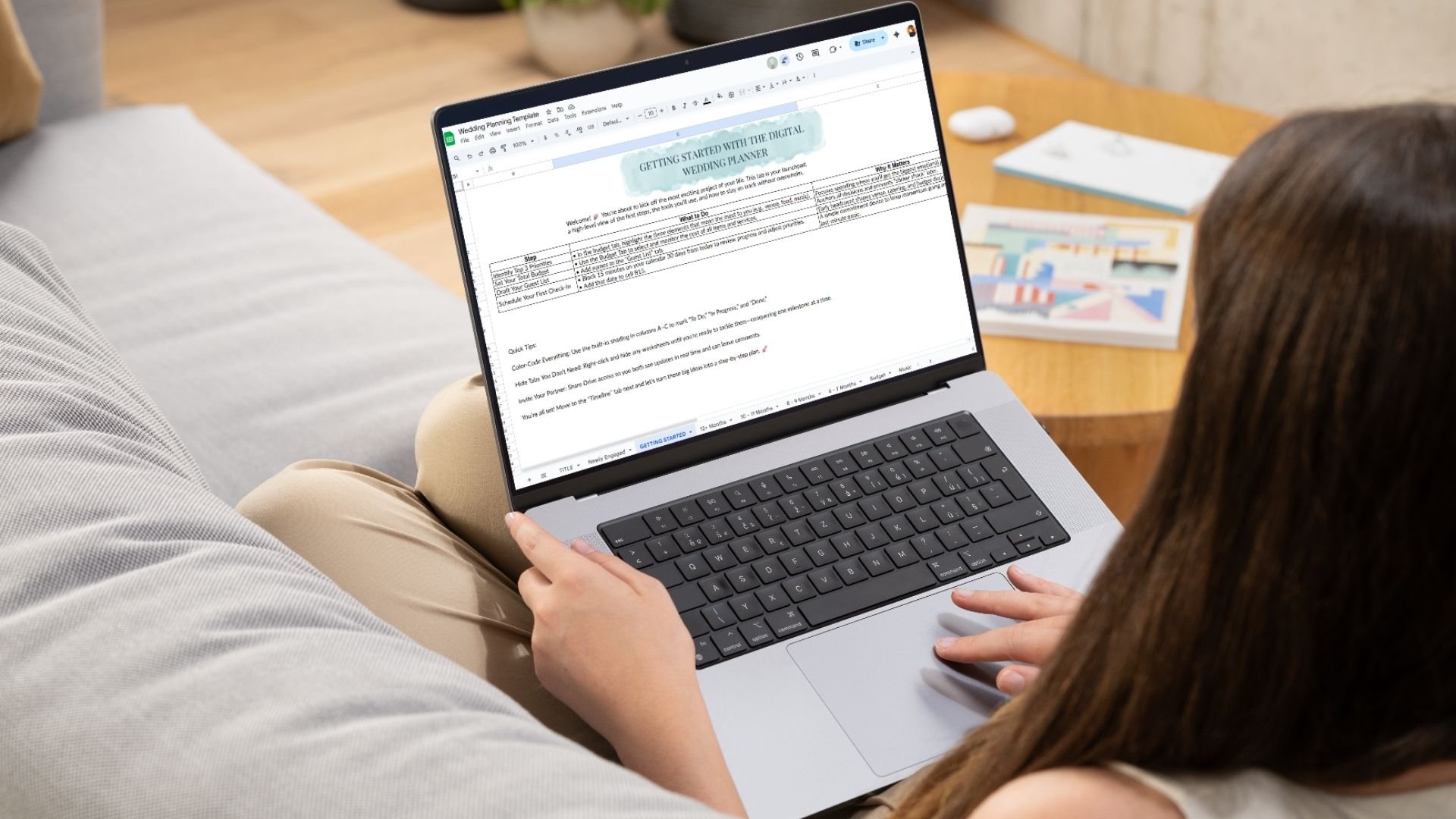 A person sitting on a couch using a laptop to edit a wedding planning template document.