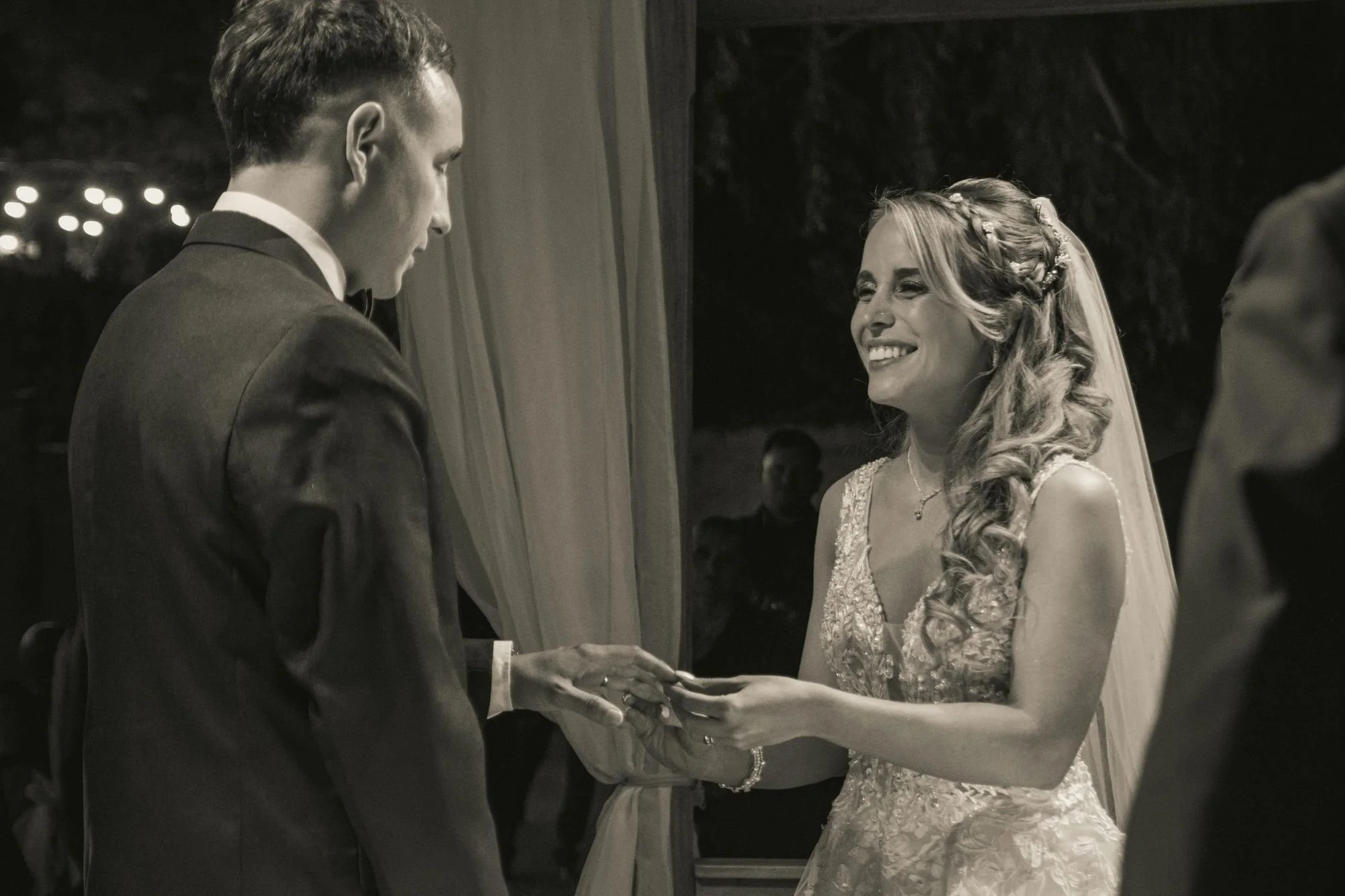 black and white photo of couple exchanging rings during vows