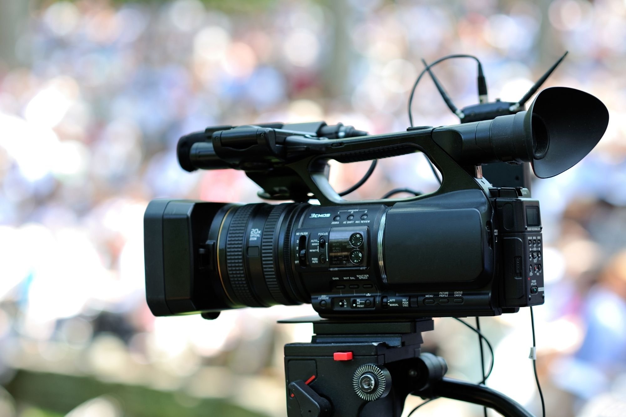 professional camcorder on tripod ready to film an outdoor wedding ceremony