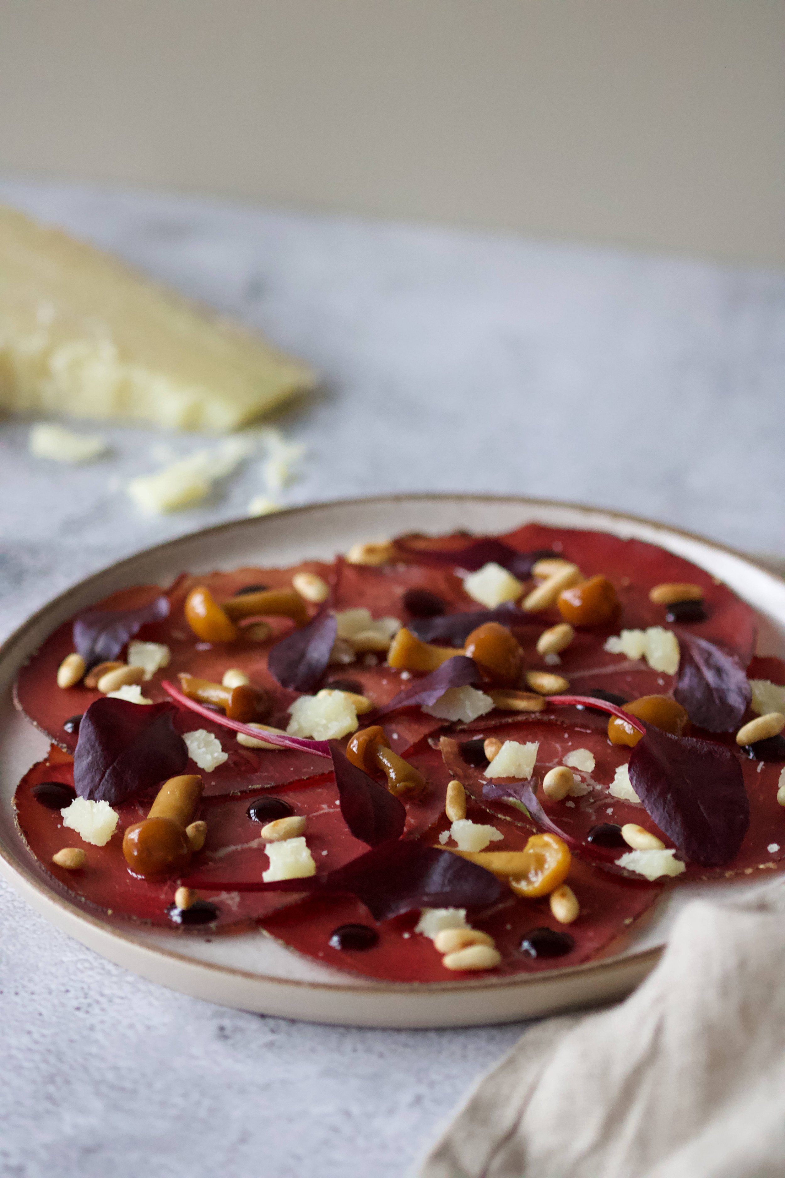 Silkeskåret bresaola med pinjekerner og mørk balsamico Glaze
