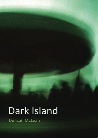 Book cover of 'Dark Island' by Duncan McLean with a dark, abstract image of a circular shape and blurry silhouettes in the background.