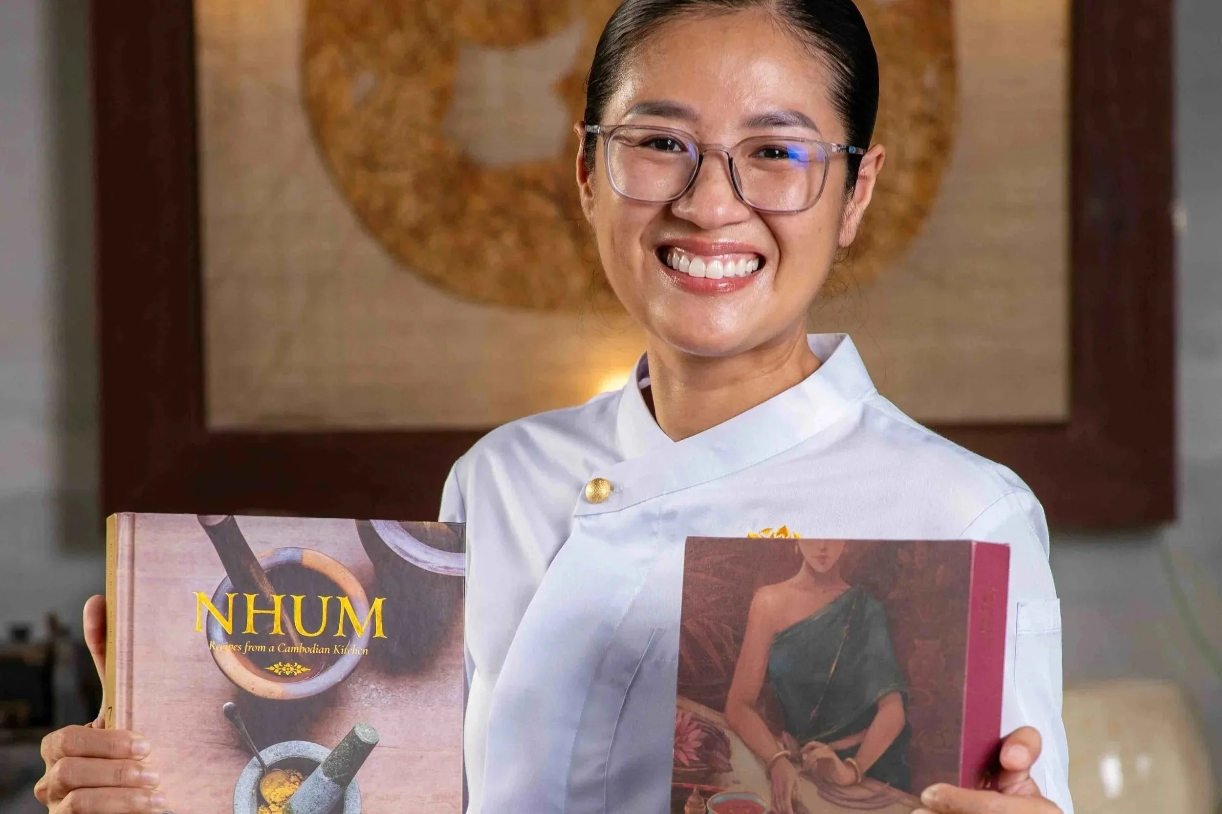 Chef Nak holding her cookbooks, NHUM and SAOY